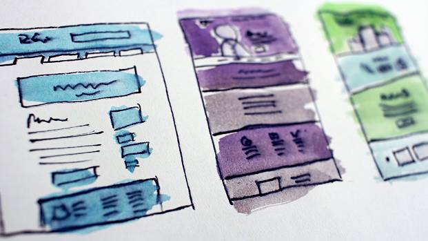 Three different pen-drawn wireframes show various digital page layouts. Each has had watercolour applied to add detail